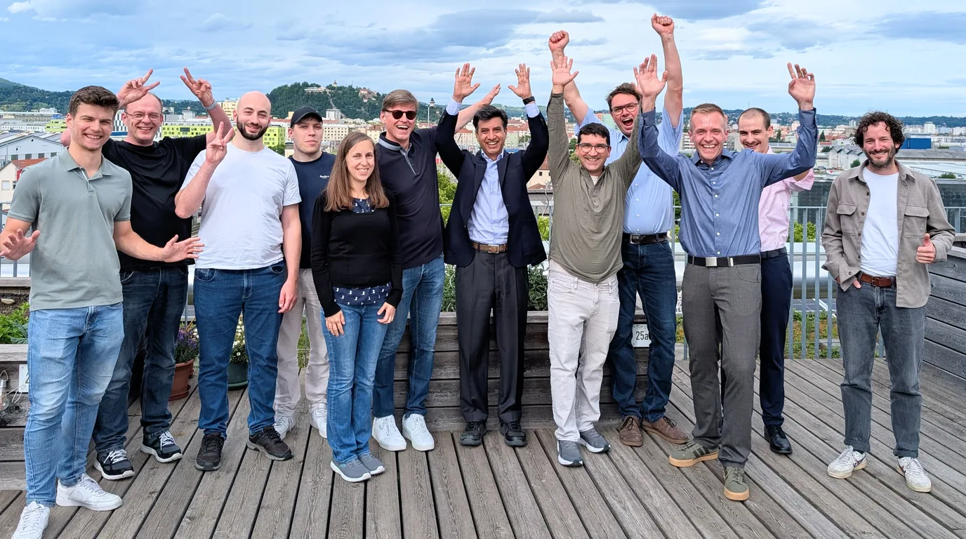 Das Team von Energiedigital mit dem Investor auf einer Dachterrasse in Graz, im Hintergrund der Schlossberg